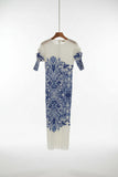 White dress with blue floral pattern hanging in a closet