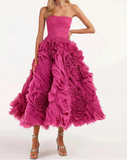 Pink strapless gown with ruffled skirt on a white background