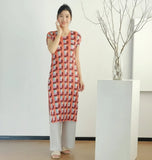Person wearing a red and white checkered dress taking a mirror selfie indoors.