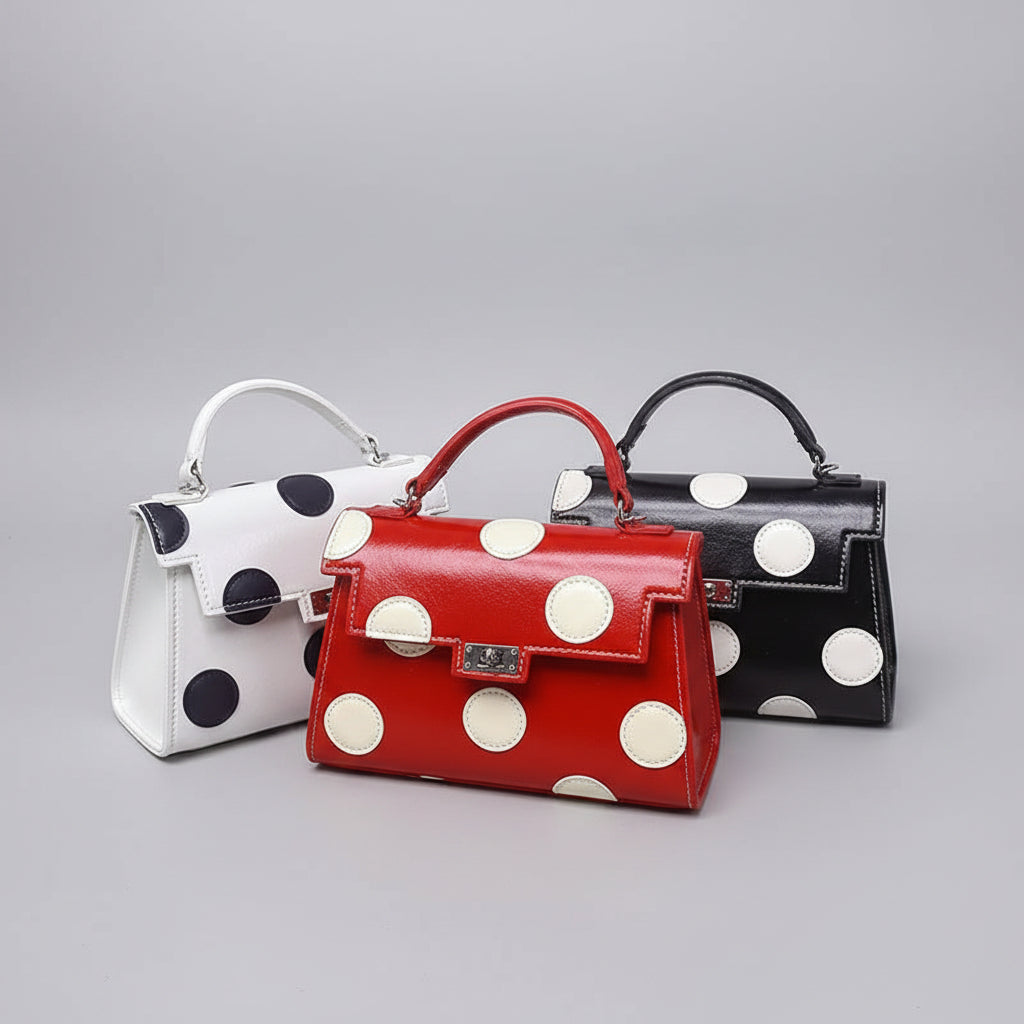 Three polka dot handbags in white, red, and black on a neutral background