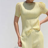 Yellow ribbed dress with short sleeves on a plain background