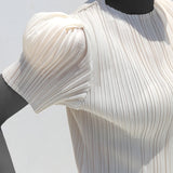 White ribbed knit top on a mannequin against a light gray background