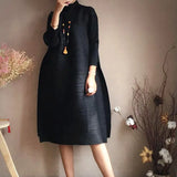 Person wearing a black dress with a neutral background