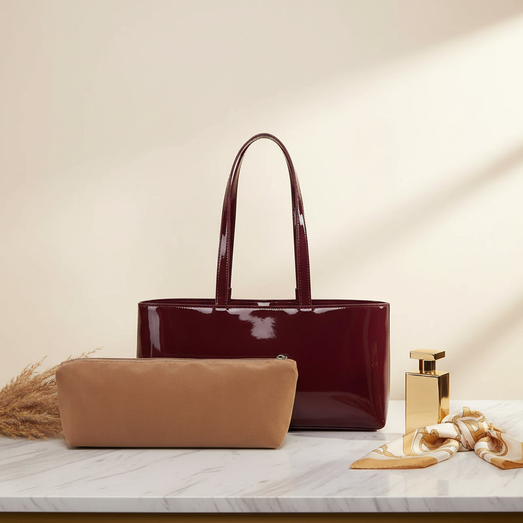 Brown clutch bag and red patent leather tote on a white background