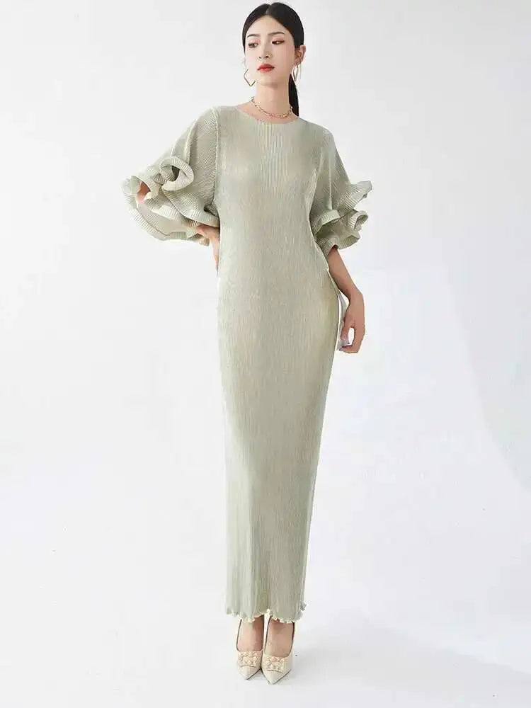 Woman wearing a light green dress with ruffled sleeves on a white background