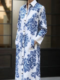 Long blue and white floral dress worn by a person indoors.