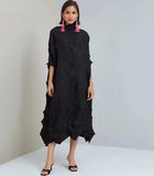 Woman wearing a black dress with a textured pattern on a white background