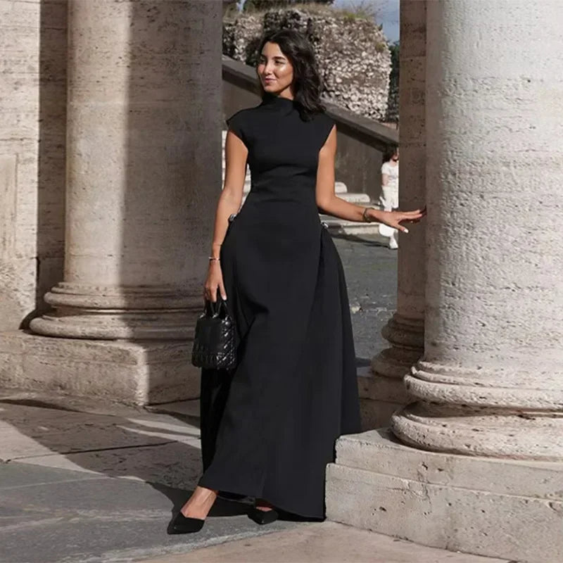 Woman in a black dress standing between stone columns