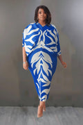 Woman wearing a blue and white patterned dress against a plain background