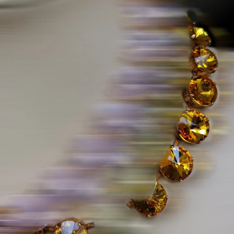 Close-up of a necklace with yellow gemstones on a blurred background