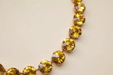 Close-up of a necklace with yellow gemstones on a blurred background