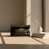 Black leather clutch bag on a white background
