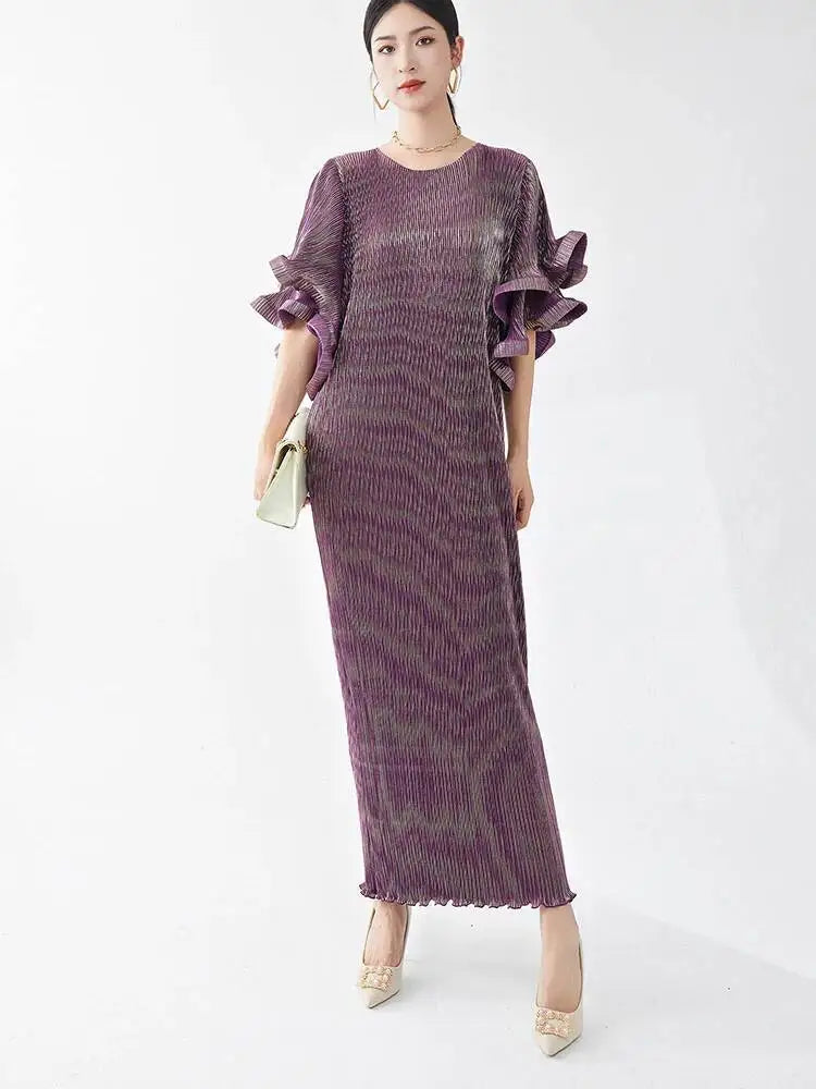Woman wearing a long purple dress with ruffled sleeves on a white background