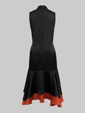 Black dress with a red hem on a gray background