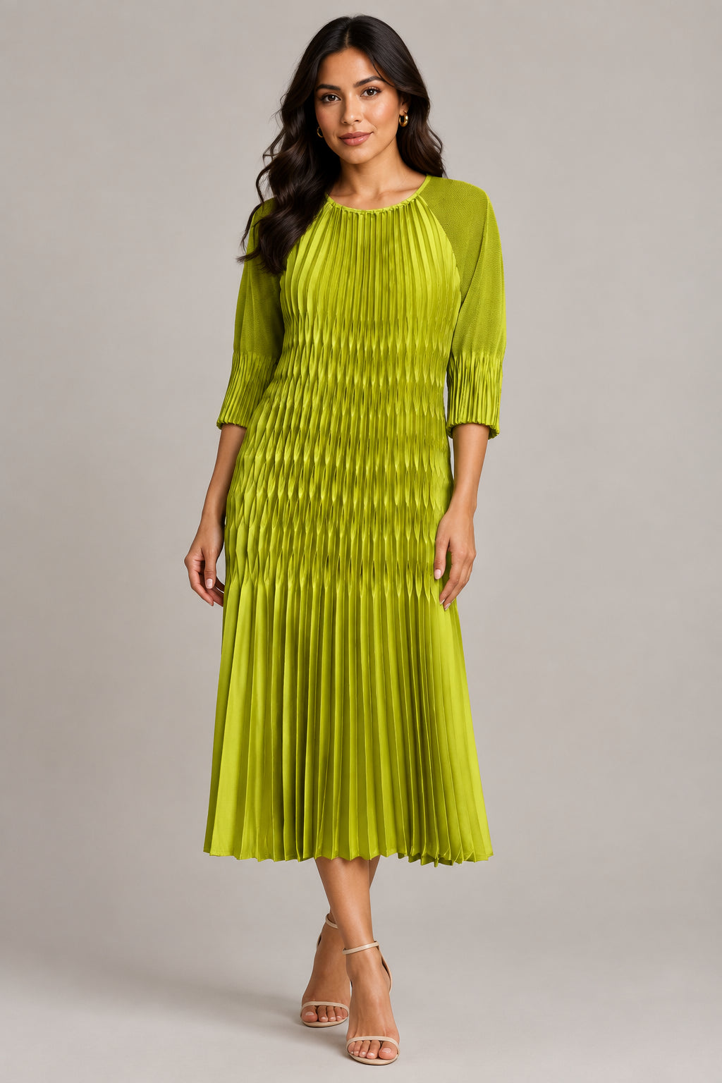 A pleated midi dress in a vibrant yellow-green color, hanging on a white hanger against a textured beige wall.