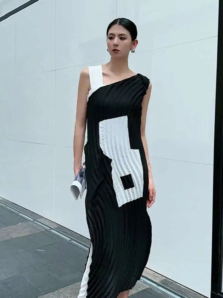 Woman wearing a black and white dress with geometric pattern in an urban setting