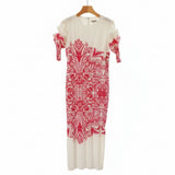 White dress with red floral pattern on a hanger against a wardrobe background