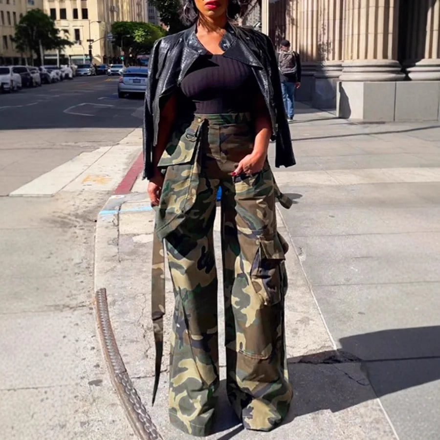 Person wearing camouflage pants and a black leather jacket on a city street.