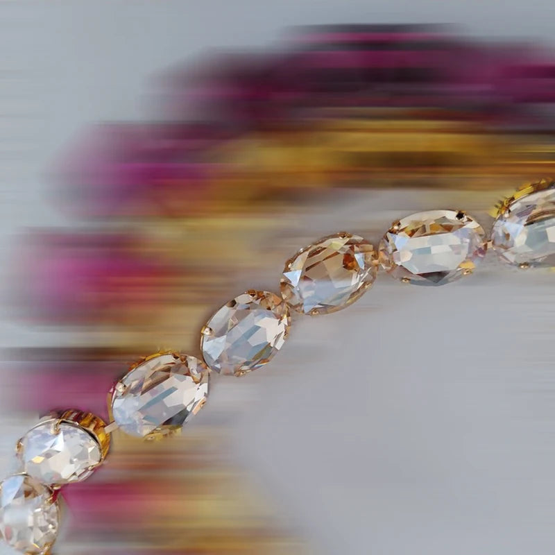 Bracelet with clear gemstones and gold accents on a blurred background