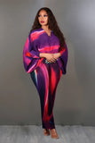Woman wearing a vibrant, multicolored outfit against a plain background